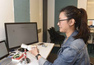student interacting with a micro-processor controlled robotic hand at IDM showcase 2017