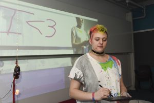Student interacting with a student project on a graphics tablet at IDM showcase 2017