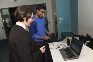 Students interacting with student project which is a controller based game on a laptop at IDM showcase 2017