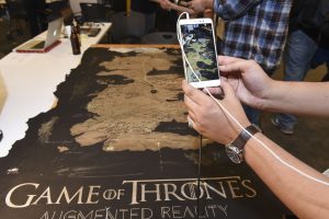 Student interacting with a mobile AR game of thrones themed project at IDM showcase 2017