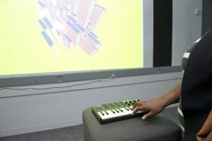 student interacting with a screen projected project through a musical keyboard at IDM 2016 showcase