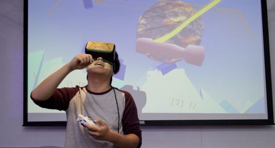 student interacting with a VR project at IDM 2016 showcase